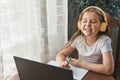 Speech training concept. Little girl uses a laptop to study at home with a teacher, a speech therapist.