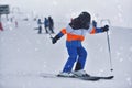 Speed and Adventure: 10-Year-Old Boy Skiing Down a Sunny Slope with the Mountain in the Background