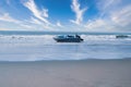 A speed boat on the beach, big waves in the sea. Royalty Free Stock Photo