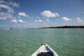 Speed boat in front of Kayak on crystal clear ocean water of Delnor Wiggins State Park of Naples