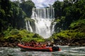 Speed boat rides under the water cascading over the Iguacu falls in Iguacu, Brazil