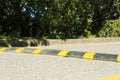 Speed bump on asphalt road near trees outdoors Royalty Free Stock Photo