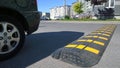 Speed bump near apartment building and school. Sleeping policeman. Road safety regulations. Traffic rules concept. Car wheel on as