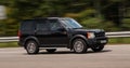 Luxury car black Range Rover speeding on empty highway