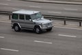 Luxury car silver Mercedes Benz G speeding on empty highway