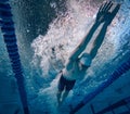Speed and endurance. Young man, professional swimming athlete in motion, training, swimming in pool Royalty Free Stock Photo