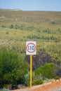 Speed limit 110 kph street sign next to Australian road Royalty Free Stock Photo