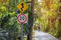 Speed limit road signs and Winding Road Sign with biker on twisty road background.Traffic signs warning drivers that conditions