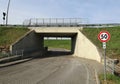 Speed limit sign in front of a concrete road underpass with sidewalks on both sides. Royalty Free Stock Photo