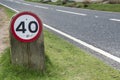 Speed limit sign on grass verge by side of road Royalty Free Stock Photo