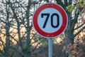 Speed limit sign for 70 km/h near the trees