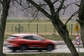 Speed limit sign on the road and a speeding red car Royalty Free Stock Photo