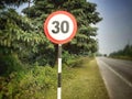 Speed limit 30 sign at the street. Round speed limit warning plant Royalty Free Stock Photo