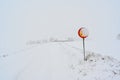 speed sign with 70 kph covered in snow