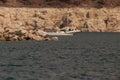 Speedboat driving at Lake Mead with low water line visible in white Royalty Free Stock Photo