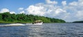 Speedboat moving in Barreirinhas on tropical Brazilian river among amazon forest