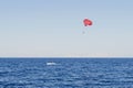A speedboat pulls a yellow parachute with a tourist. Extreme entertainment for tourists on the sea. Sport activity - Parasailing Royalty Free Stock Photo