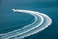 Speedboat runs fast in the open sea and leaves the engine`s wake in the water