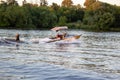 Speedboat towing an athlete on a Board against the background of the forest. Athlete water skiing and having fun. Royalty Free Stock Photo