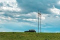 Speeding car on country road with electricity pylon in background Royalty Free Stock Photo