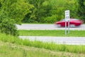 Speeding Red Car Races Past Speed Limit Sign Royalty Free Stock Photo