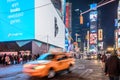 Speeding Taxi in New York City Times Square. Big Animated LED Screens and Toshiba Tower in Background Royalty Free Stock Photo