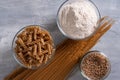 Spelt pasta, spelt grain and whole grain spelt flour in bowl and jar. Top view. Royalty Free Stock Photo