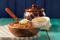 Spelt porridge buttered in wooden bowl and raw spelt in linen ba