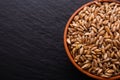 Spelt seeds on a dark stone background