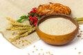 Spelt whole grain flour in ceramic bowl, wheat ears and homemade roll bun