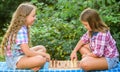 spend time together. family time. two concentrated girls play chess. chess playing sisters. skilled children. turn on