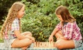 Spend time together. family time. two concentrated girls play chess. chess playing sisters. skilled children. turn on