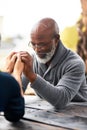 Spending a little time in prayer. a senior couple holding hands in prayer while sitting outside. Royalty Free Stock Photo