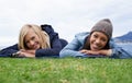 Spending some time with my best friend. Two young women smiling while lying on the lawn outside. Royalty Free Stock Photo