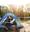Spending time in the great outdoors together. an adventurous couple out camping with their dog. Royalty Free Stock Photo