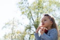 Spending time outside. Beautiful little girl with headband in spring day in the park. Close up view of little girl who Royalty Free Stock Photo