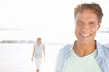 Spending time at sunset. A handsome mature man enjoying a walk on the beach with his wife. Royalty Free Stock Photo