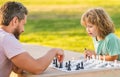 spending time together. strategic and tactic. tutorship. dad and kid play logic game.