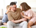 Positive happy family of three enjoying carefree time together at home, dad playing with kids Royalty Free Stock Photo