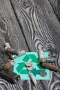 Spent finger-type batteries coated with corrosion. Waste recycling sign. They lie on brushed pine boards painted in black and Royalty Free Stock Photo