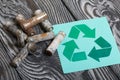 Spent finger-type batteries coated with corrosion. Waste recycling sign. They lie on brushed pine boards painted in black and Royalty Free Stock Photo