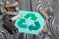 Spent finger-type batteries coated with corrosion. Waste recycling sign. They lie on brushed pine boards painted in black and Royalty Free Stock Photo