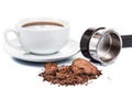 Spent or used coffee grounds with portafilter and a cup of freshly brewed coffee in the background Royalty Free Stock Photo