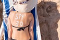 Spf 30 word is drawn with sunblock on woman`s back lying on the sunbed at the beach. Sun protection factor concept Royalty Free Stock Photo