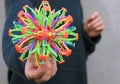 Sphere hoberman, a folding ball of rainbow color in the girls hand