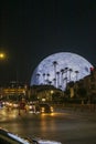 The Sphere at The Venetian Resort with lush green palm trees and cars driving on the street at night in Las Vegas Nevada