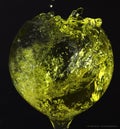 A spherical glass-shaped glass with a yellow liquid splash Royalty Free Stock Photo