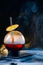 Spherical glass with smoke and alcohol. Caramelized Lemon Slices. Smoke on a black background. Royalty Free Stock Photo