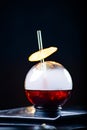 Spherical glass with smoke and alcohol. Caramelized Lemon Slices. Smoke on a black background