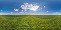 spherical 360 hdri panorama among green grass farming field with clouds on blue sky in equirectangular seamless projection, use as Royalty Free Stock Photo